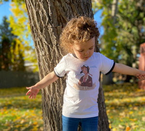 Little girl wearing Amelia Earhart t-shirt and spreading her arms like wings and pretending to fly