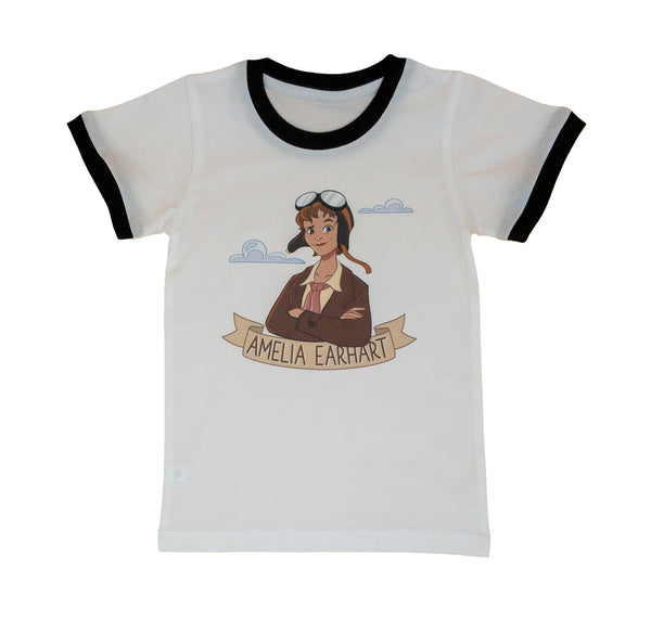 White ringer t-shirt with black ring collar and sleeve cuffs. Image of cartoon illustrated Amelia Earhart wearing her flight goggles on her forehead, rose-coloured scarf and brown leather bomber jacket. Two light blue clouds in the background. Below her image is a light brown ribbon bearing her name.